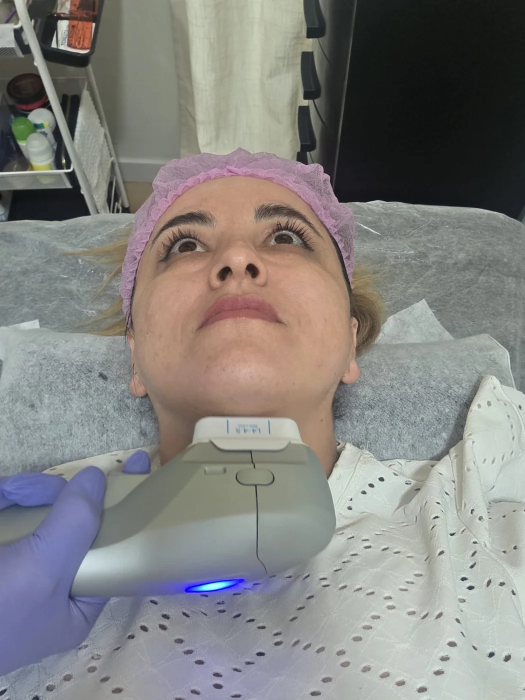 Cabezal de aparatología facial trabajando el cuello de una clienta